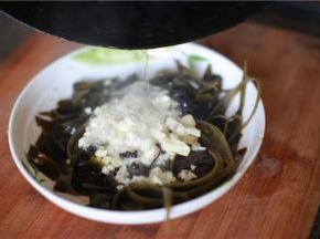 淋上调料，大蒜沫铺满海带丝。