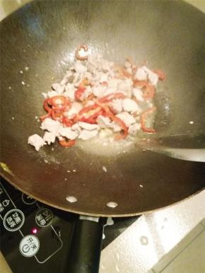 开火热锅放油，先把瘦肉爆炒好（同时把切好的蒜粒和辣椒加入一起炒）