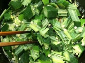 锅内加油炒热并加入秋葵煸炒