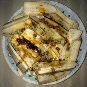 把蒜蓉、盐、食用油、生抽倒进茄子里涂抹均匀后放进锅里蒸