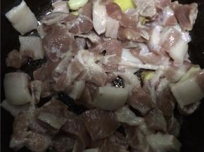 将姜丝、大蒜倒入热油锅爆香，加入肉片翻炒