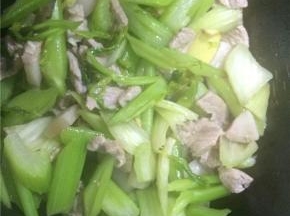 西芹炒至七成熟后倒入肉片一起翻炒均匀，加入生抽和盐
