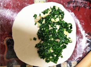 在擀好的面皮上放入韭菜鸡蛋虾仁馅，如下图放置一半即可。