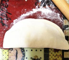 如下所示，将另一半未放馅料的面皮翻上去，用手压紧面皮边缘。