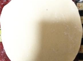 发酵好的面放入小苏打揉搓表面光滑，分成若干份小面团，并取其中一份擀开。