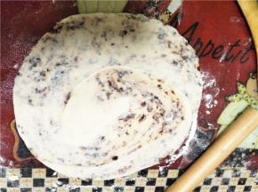 用擀面杖把面团擀开成饼状