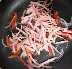 放入火腿丝、甜椒及干辣椒继续翻炒。