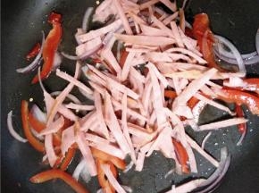 放入火腿丝、甜椒及干辣椒继续翻炒。