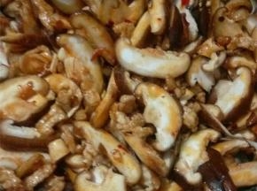 翻炒一会后，倒入香菇