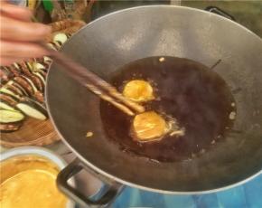 将裹好的茄饼放入锅中油炸