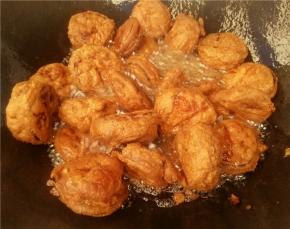 在将炸好装盘的茄饼倒入锅中再炸一遍