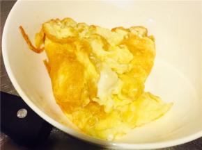 先热油将鸡蛋液倒入锅中，中火让蛋液变成蛋饼，盛入碗中备用；