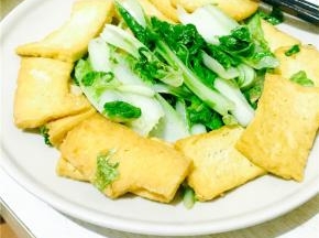 放入煎好的豆腐，和青菜一起翻炒均匀；锅中加一点水，微炖一下，最后加入盐和鸡精即可。