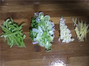 将粉丝放入冷水中浸泡，佐料准备：姜和青椒切丝、蒜切末、葱切碎