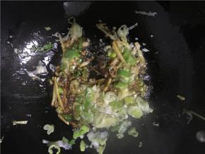 倒入备好的姜丝、青椒丝、葱花、蒜末，炒几下倒入盐和酱油