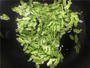 将火开至中火，加热几秒钟，倒入切好的苦瓜翻炒