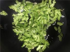将火开至中火，加热几秒钟，倒入切好的苦瓜翻炒