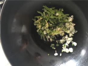 倒入备好的姜丝、青椒丝、葱花、蒜末，炒几下倒入盐和酱油