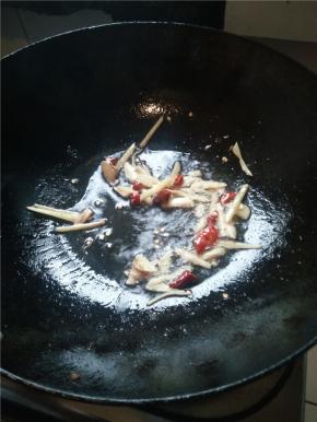 用小火将油热致7-8成熟时，将切好的姜蒜、干辣椒倒入锅中翻炒 。