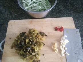 豇豆切段，酸菜和姜蒜辣椒切碎备用。