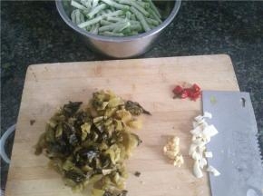 豇豆切段，酸菜和姜蒜辣椒切碎备用。