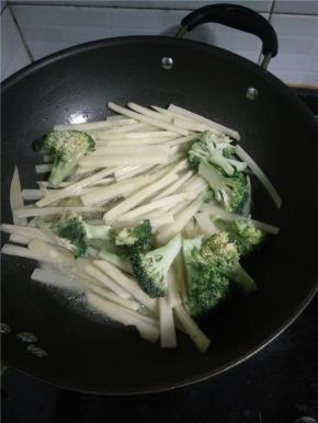 锅内放油将土豆条、花椰菜油炸一会儿。