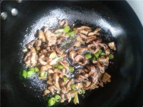 锅内放油下蒜、辣椒和香菇，有香味后马上下肉条。