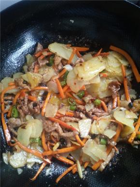 翻炒均匀后，放入土豆片和胡萝卜条，翻炒4、5分钟，放入豆豉、酱油、盐。