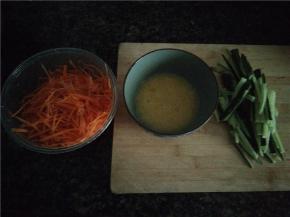 胡萝卜用刮丝器刮丝，黄瓜切条，鸡蛋放少量盐打散备用。