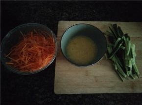 胡萝卜用刮丝器刮丝，黄瓜切条，鸡蛋放少量盐打散备用。