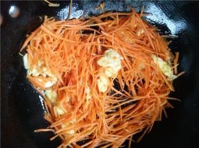 锅内放油煎蛋，差不多成型的时候炒散下胡萝卜丝。