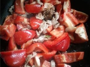 锅内放油下蒜瓣，有香味后马上下肉片，肉片炒至变色后下甜椒。