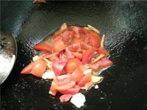 火上架锅，热锅冷油，下蒜和生姜丝，翻炒出香味，下番茄继续翻炒，放盐调味