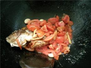 等番茄炒软后，就放入煎好的鱼，稍微翻一翻