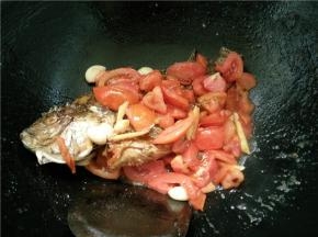 等番茄炒软后，就放入煎好的鱼，稍微翻一翻