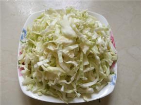将卷心菜切成宽约1厘米的丝，装盘待用