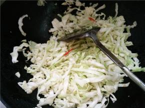 将切好的卷心菜丝下锅，加适量的食盐、生抽翻炒至柔软