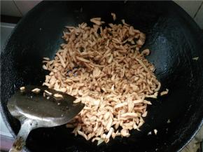 再将炒好的萝卜干放进锅中，跟猪肉一起炒，加食盐和生抽，翻炒