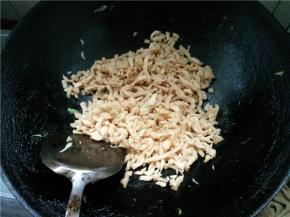 锅里不放油，下切好的萝卜干块翻炒，炒掉萝卜干中的水分，略焦黄，铲出装盘待用