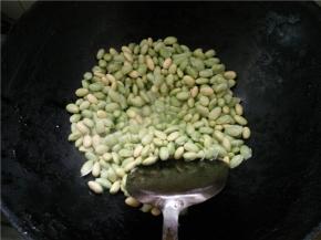 热锅下油烧热，放入剥好的毛豆，加入食盐翻炒一会儿