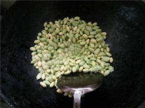 热锅下油烧热，放入剥好的毛豆，加入食盐翻炒一会儿