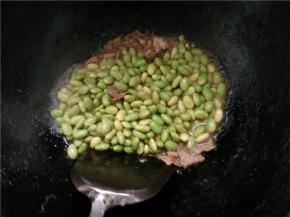 翻炒一会后，加入炒好的毛豆，继续翻炒