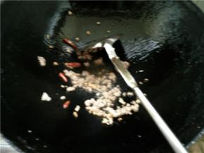 等辣椒和蒜末炒出香味后，放入肉末炒香，放一些盐调味