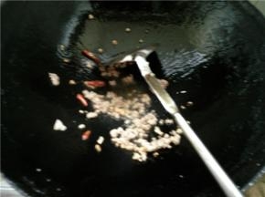 等辣椒和蒜末炒出香味后，放入肉末炒香，放一些盐调味
