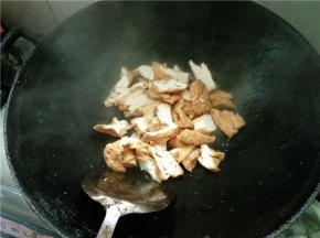 热锅下油烧热，下切好的三角豆腐加食盐翻炒