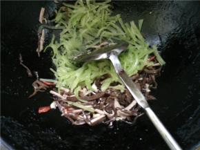翻炒一会后，加入切好的木耳丝和青笋丝继续翻炒