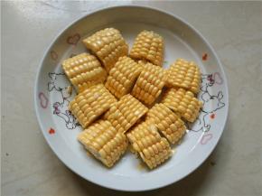 将洗好的玉米切成两指宽的粗段，再对开切开，装盘待用