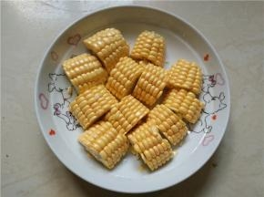 将洗好的玉米切成两指宽的粗段，再对开切开，装盘待用