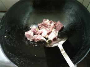 热锅下油烧热，加入生姜和排骨，翻炒一会儿，加盐调味