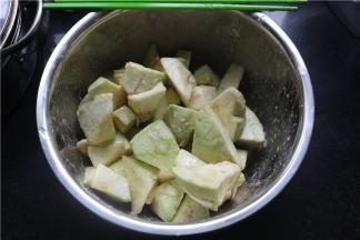 将茄子去皮，滚刀切成方块，在盆里打入一个鸡蛋，3勺淀粉搅拌均匀。